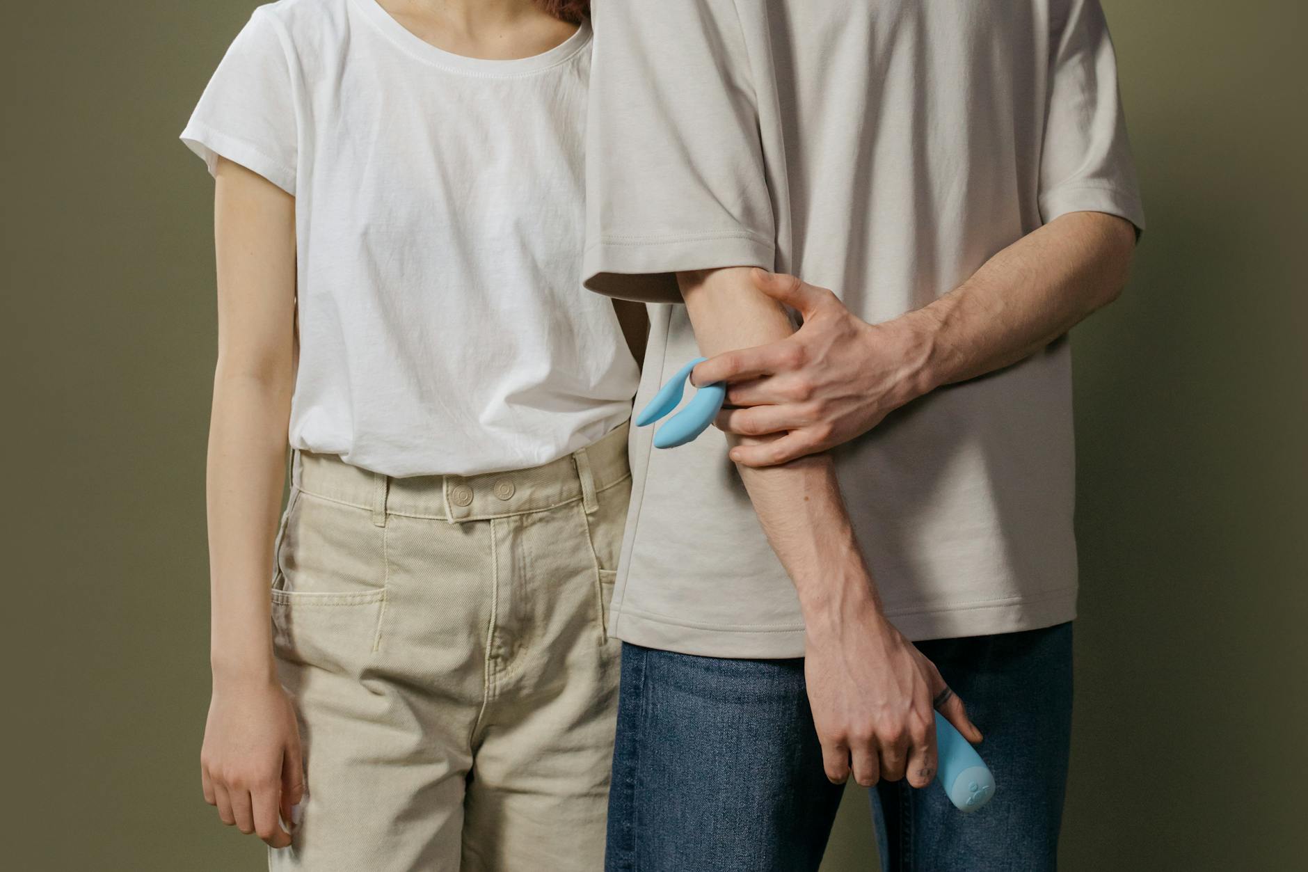 A woman holding colorful silicone vibrators in a moment of personal reflection and self-discovery