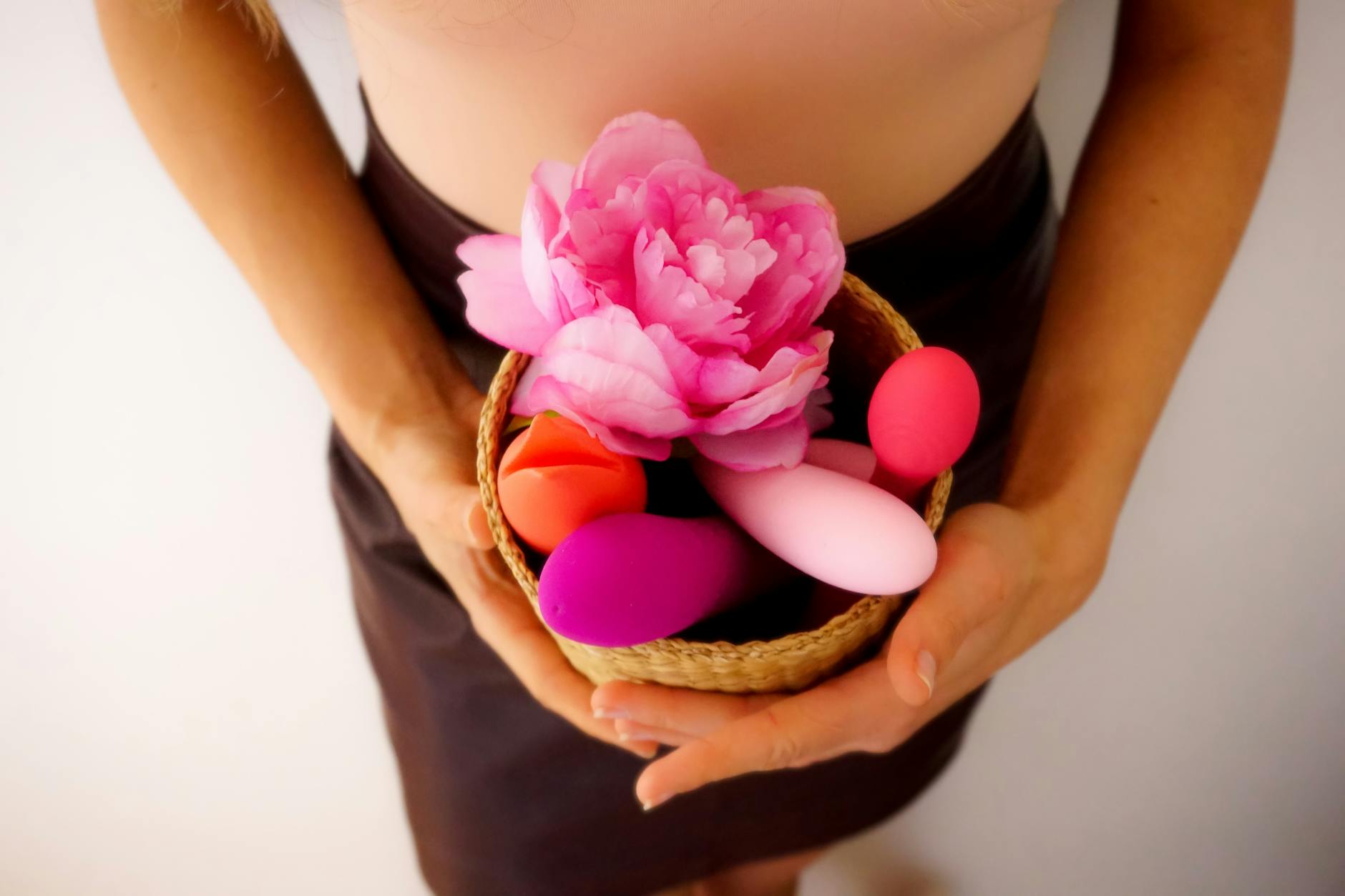 A collection of colorful personal pleasure devices in a woven basket